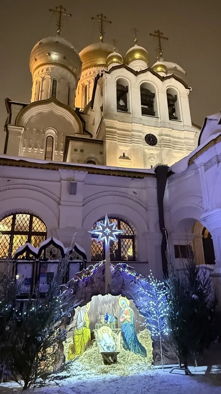 Une crèche de Noël illuminée dans la cour d'un monastère, la nuit
